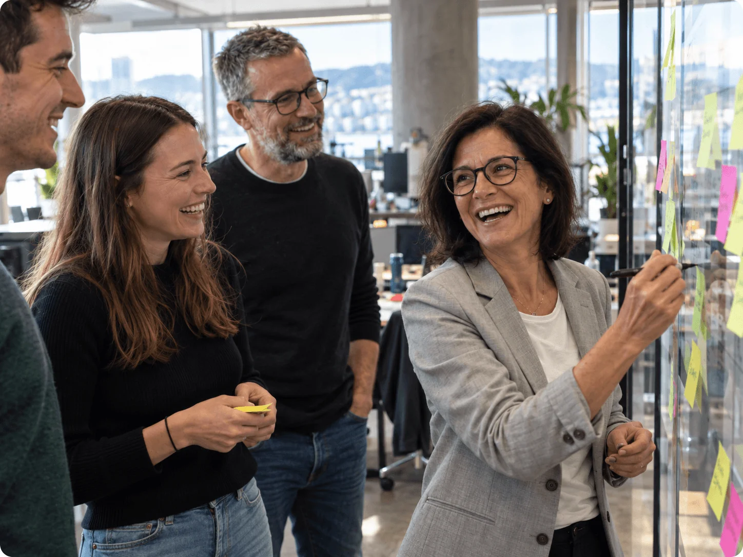 Generationenübergreifendes Team beim Brainstorming mit Haftnotizen im modernen Büro